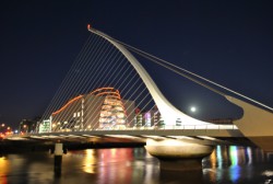 The iconic Samuel Beckett Bridge backlit by the full moon and the Convention Centre
